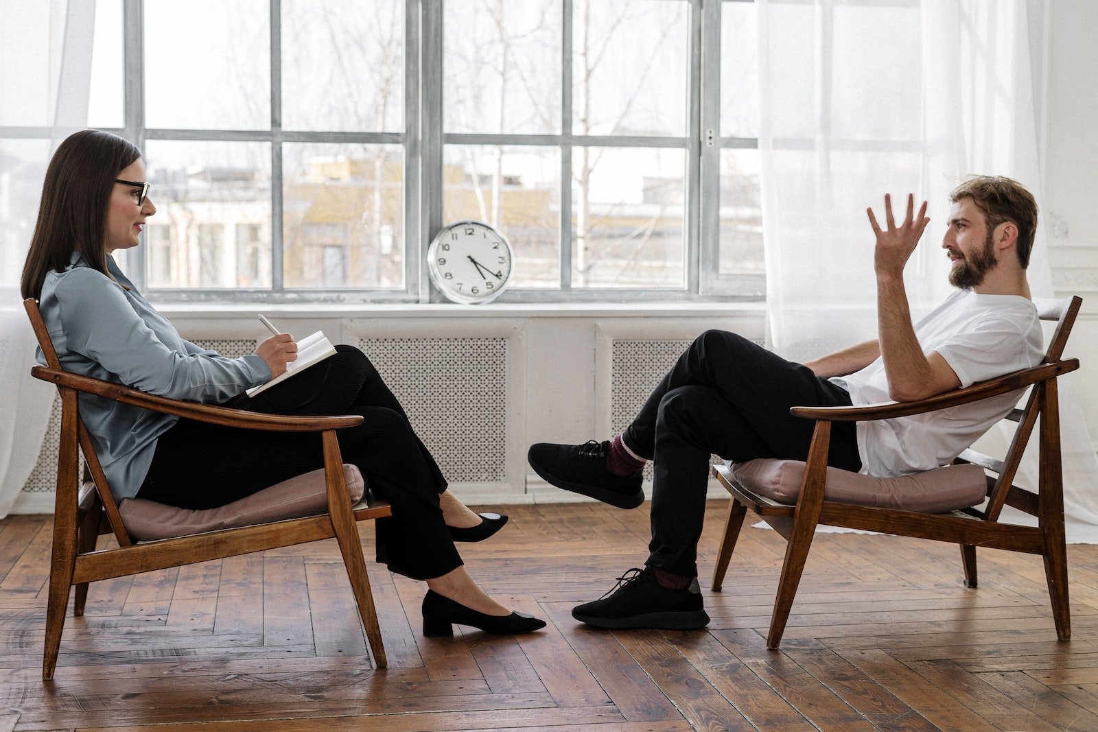 Person in Black Pants and Black Shoes Sitting on Brown Wooden Chair, Jungian-based transcendence therapy