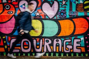 man walking beside graffiti wall, Courage