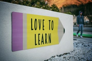 love to learn pencil signage on wall near walking man, Seeking knowledge